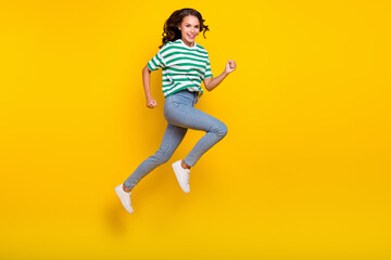 Fototapeta na wymiar Full size profile side photo of young cheerful girl runner energetic speed jump isolated over yellow color background