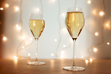 Two flute glasses of champagne or sparkling wine in a Christmas or New Year atmosphere, bokeh lights in the background