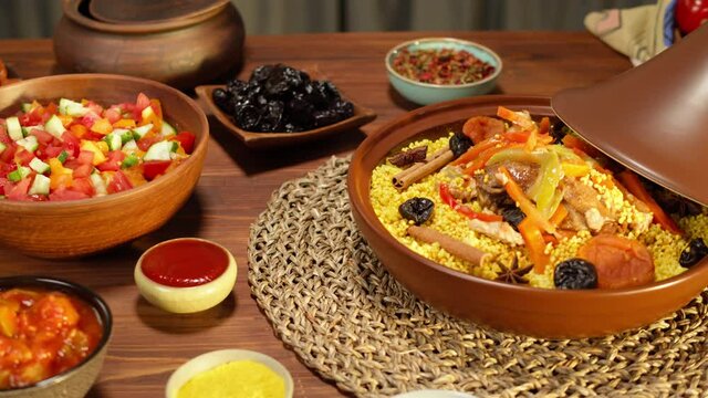 Moroccan cuisine top view. Tajine, traditional dish made of lamb and eggplant, vegetable salad. Middle eastern culture. Couscous with mutton close-up, delicious rice. Homemade food.