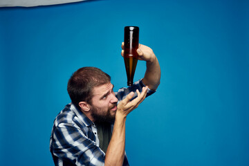a person drinking beer alcohol emotion blue background