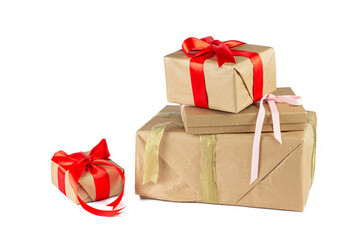 Gift box wrapped in Kraft paper with red and golden ribbon on white background. Holiday or Christmas gift boxes background.