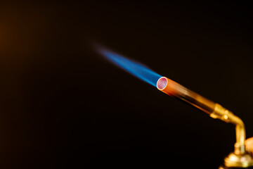 Blue flame from a gas brass torch burner on black background