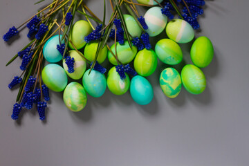 Easter background with Easter green eggs and blue flowers