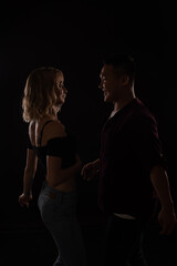 a man and a woman dance to music in the darkness of a disco