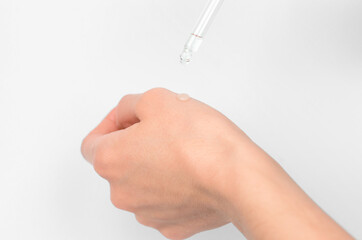 A drop of essential oil on a female hand, close-up, selective focus