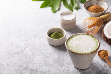 Matcha latte, Japanese green tea with coconut milk,  traditional bamboo whisk on white background