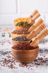 Assortment of beans, seeds, legumes on white concrete background.