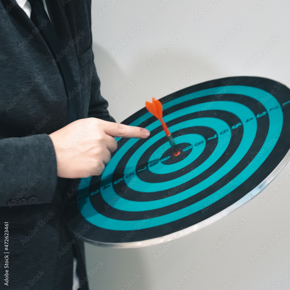 Aufkleber close up shot of the dart arrow hit on bulleyes of dartboard to represent that the business reached 