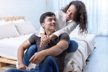 Fototapeta premium Happy young couple hugging and laughing in bedroom.
