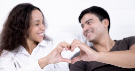 The young couple in love spend time together on Valentine's Day, Closeup of couple making heart shape with hands.