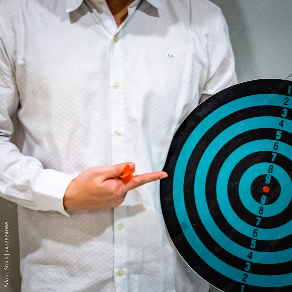 Poster close up shot of the dart arrow hit on bulleyes of dartboard to represent that the business reached 