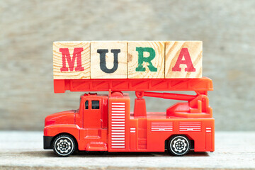 Fire ladder truck hold letter block in word mura on wood background - obrazy, fototapety, plakaty