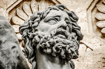 Naklejka premium Stone sculpture showing head of man with curly hair
