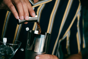 man about to prepare a cocktail in a metal shaker