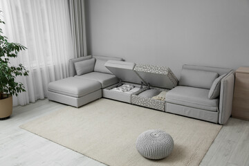 Modular sofa with storage near wall in living room. Interior design