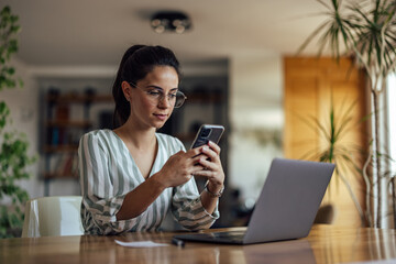Focused caucasian woman, messaging her coworkers.