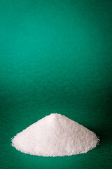 Heap of sugar on green background