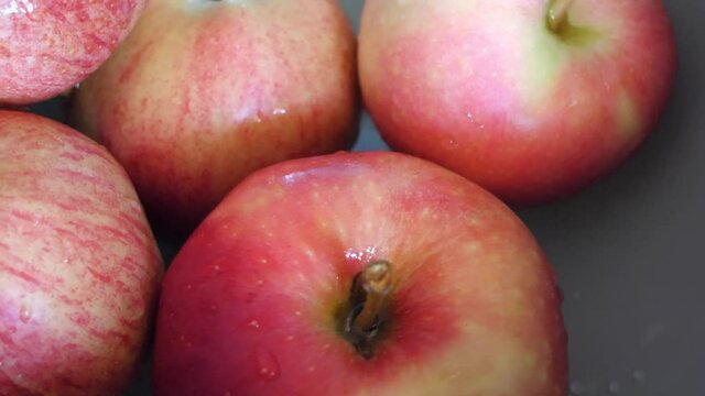 Water drops on apples of the Ligol and gala varieties, rotation, close-up.
