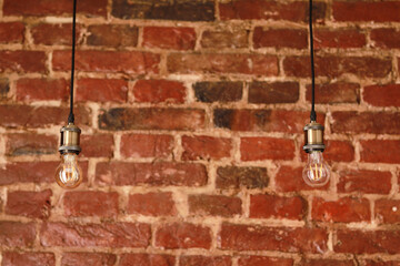 Decorative antique edison style light bulbs against brick wall background