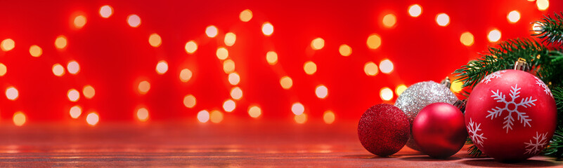 Christmas decoration on wooden table with red background and bokeh lights