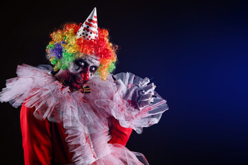 Terrifying clown on dark background, space for text. Halloween party costume