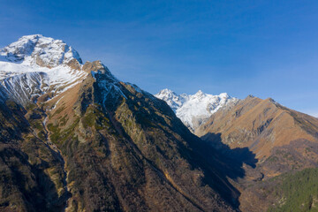 Scenic autumn mountain landscape with snow peaks, Tuymazinsky glacier, Digor Gorge, Northern Ossetia, Caucasus, Russia