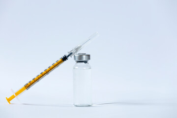 The vaccines vials glass bottle and disposable syringe on white