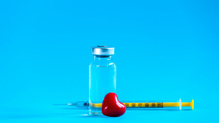 The vaccination fluid bottle with a syringe and a little red heart