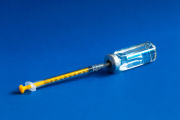 the vaccine bottle lies with the syringe