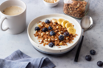 Granola with yogurt, blueberries, nuts, banana and honey. Muesli. Healthy eating. Vegetarian food.