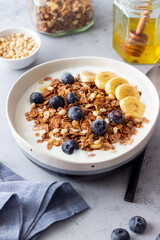 Granola with yogurt, blueberries, nuts, banana and honey. Muesli. Healthy eating. Vegetarian food.