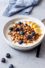 Granola with yogurt, blueberries, nuts, banana and honey. Muesli. Healthy eating. Vegetarian food.