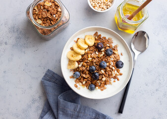 Granola with yogurt, blueberries, nuts, banana and honey. Muesli. Healthy eating. Vegetarian food.