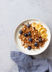 Granola with yogurt, blueberries, nuts, banana and honey. Muesli. Healthy eating. Vegetarian food.