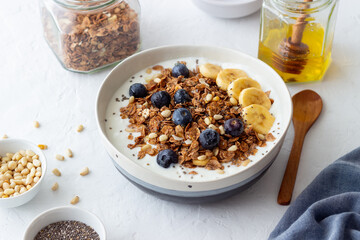 Granola with yogurt, blueberries, nuts, banana and honey. Muesli. Healthy eating. Vegetarian food.