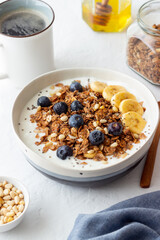Granola with yogurt, blueberries, nuts, banana and honey. Muesli. Healthy eating. Vegetarian food.