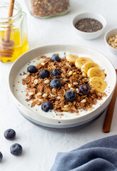 Granola with yogurt, blueberries, nuts, banana and honey. Muesli. Healthy eating. Vegetarian food.