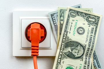 Dollar banknotes with an electric plug - electricity cost concept