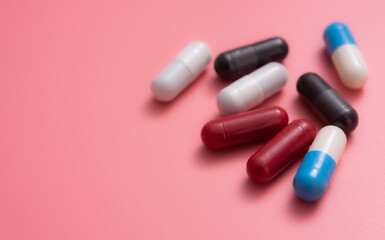 Multicolored pills,various capsule on a pink background