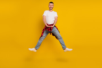 Fototapeta na wymiar Full size photo of amazed man wear plaid shirt on waist jump up sale isolated on yellow color background