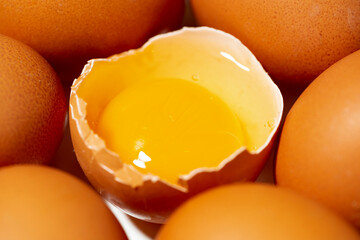fresh chicken eggs on white background, one broken egg, closeup