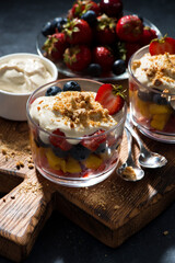 fresh fruit with custard in glasses, vertical closeup