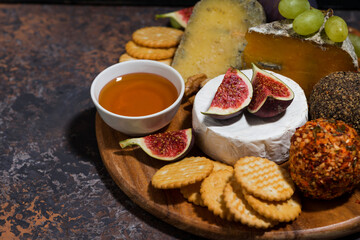 gourmet cheeses on dark background