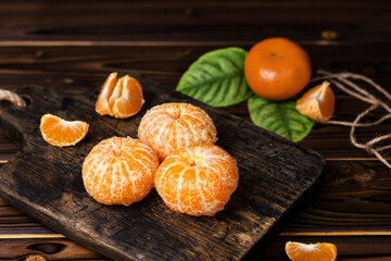 ripe orange sweet tangerines on wooden board