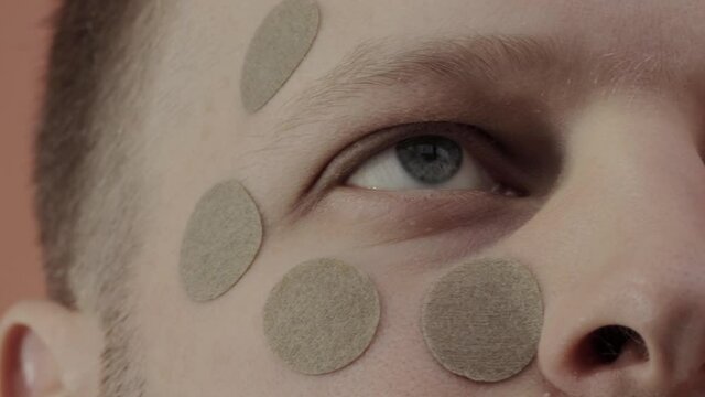 Herbal patch for the face and eyes, to improve vision, relax the muscles of the face. A man with a round herbal patch on his face. Close-up