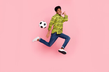 Fototapeta na wymiar Full size photo of young funky brunette guy jump play ball wear shirt jeans sneakers isolated on pink background