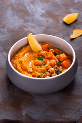 Hummus with sweet potato, chickpea, tahini, garlic and olive oil topped with lemon slice, herbs and sumac. Middle Eastern cuisine meal