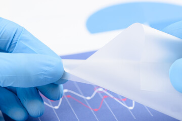 Flexible semitransparent plastic like material in scientist hands. Polymer material with new...