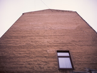 A wall of a tall prewar house with one window