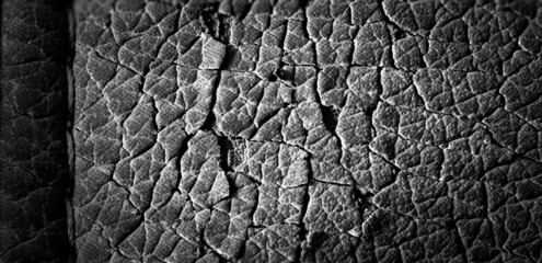 Focus stack macro of cracked faux leather on furniture with visible damage.